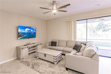 Living room featuring ceiling fan and light tile p