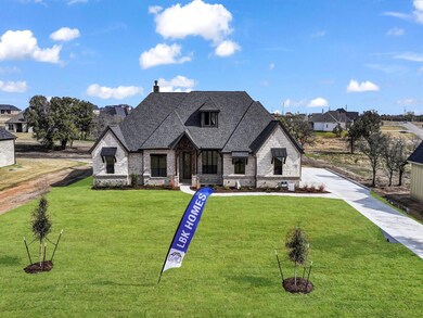 French country inspired facade with a front lawn