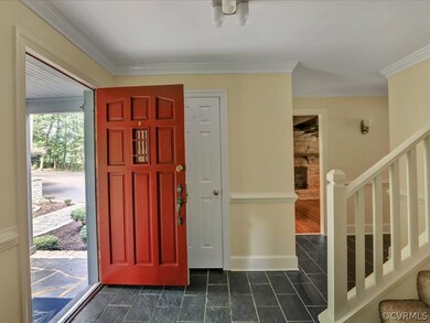 Welcoming front foyer has slate floor, chair rail