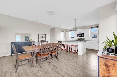 Dining room with light wood-style floors and plenty of natural light