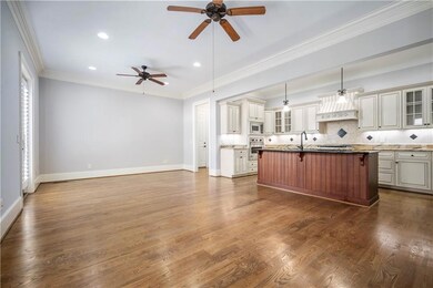 Kitchen with stainless steel appliances, a ceiling fan, open floor plan, recessed lighting, and glass insert cabinets