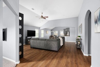 Living room with arched walkways, lofted ceiling,