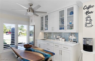 Kitchen with a sink, white cabinetry, light stone