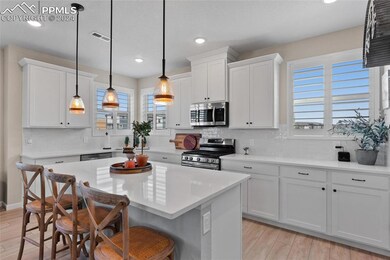 Kitchen featuring light hardwood / wood-style flooring, stainless steel appliances, a center island, hanging light fixtures, and a breakfast bar