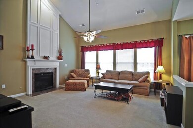Two-story great room includes a fireplace with gas logs