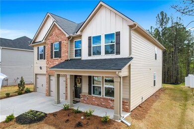 View of front of property with a porch, a garage, 