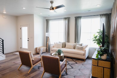 Living area with stairway, wood finished floors, recessed lighting, and ceiling fan