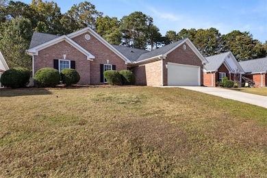 Ranch-style house featuring brick siding, driveway, a front lawn, and a garage