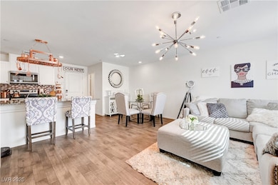 Living area featuring a chandelier, light wood-sty