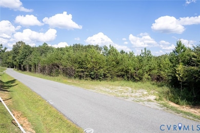 View of asphalt street featuring a wooded view
