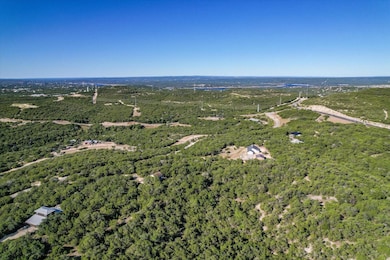 Aerial view of property and surrounding area featuring a forest