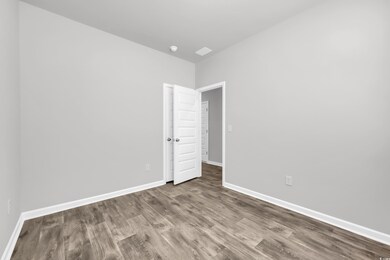 Spare room featuring wood finished floors and baseboards