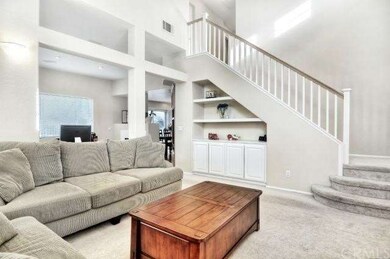 Living room features built in cabinets and shelves