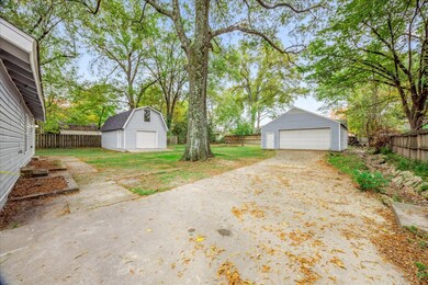 Fenced backyard featuring an outdoor structure and a detached garage