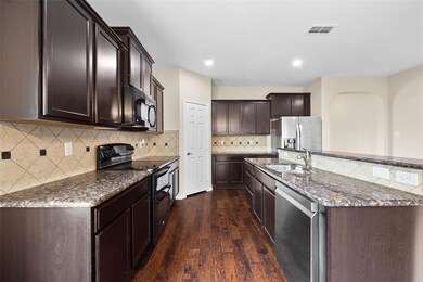 Kitchen with black appliances, decorative backspla
