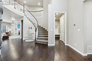 Foyer entrance with ceiling fan, a high ceiling, a