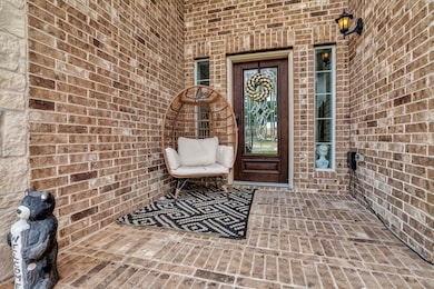 ...featuring a fully bricked, grand front porch with tall door and sidelights. Above the door are second-story windows as well!