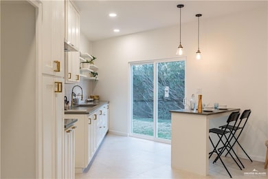 Bar with pendant lighting, recessed lighting, and decorative backsplash