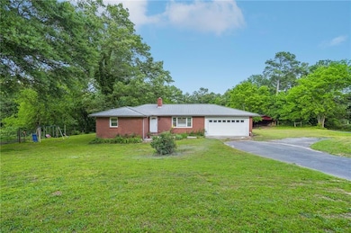 Ranch-style home with asphalt driveway, a garage, 