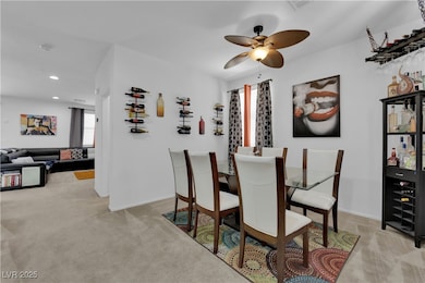 Dining area featuring light carpet, a ceiling fan,
