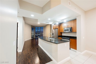 Kitchen with brown cabinetry, visible vents, a sin