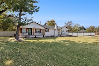 Back of house with a chimney and covered porch