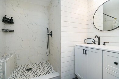 Ensuite Bath boasting a Walk-In Shower with Herringbone Tile and Sleek Black Fixtures.