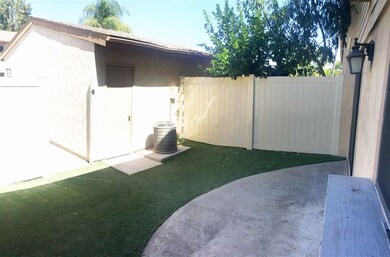 Back patio with artificial grass leading to garage