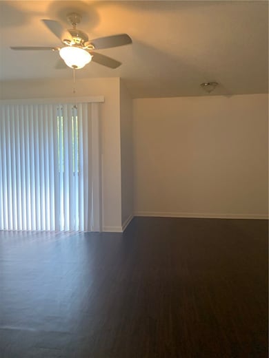Empty room featuring a ceiling fan and baseboards