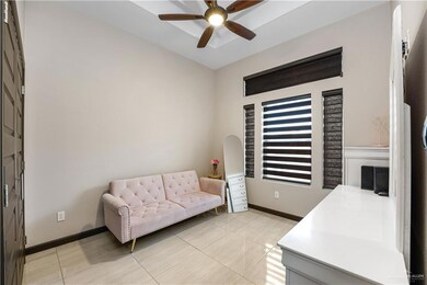 Sitting room with a ceiling fan, light tile patterned floors, and baseboards