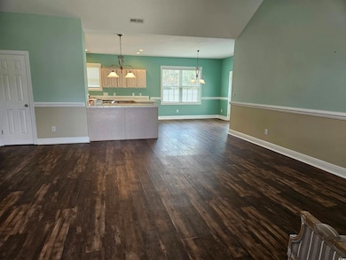Unfurnished living room with a chandelier and dark wood-style floors