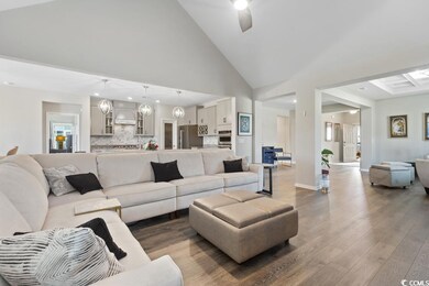 Living area featuring wood finished floors, high vaulted ceiling, a ceiling fan, and recessed lighting