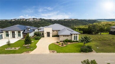 View of front facade with a standing seam roof, concrete driveway, metal roof, and a front lawn