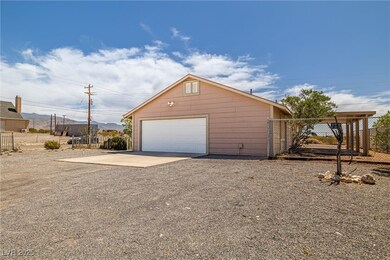 Detached garage featuring fence, gravel driveway,