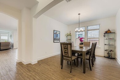 Dining space with wood tiled floors, arched walkways, and a chandelier