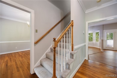 Foyer and front entry has hardwood floors and crow