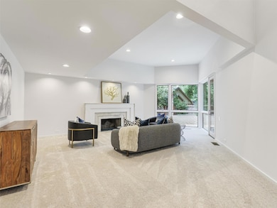 Carpeted living room with a high end fireplace and