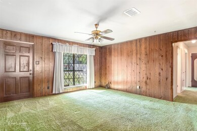 Empty room featuring wooden walls, ceiling fan, an