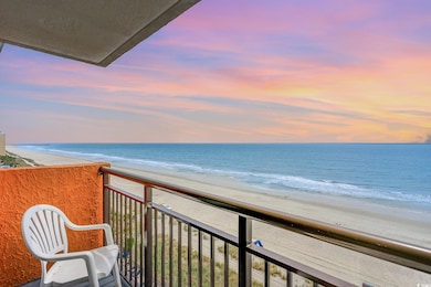 Balcony at dusk with a beach view and a water view