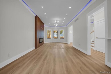 Unfurnished living room with ornamental molding, recessed lighting, light wood-style flooring, and stairway