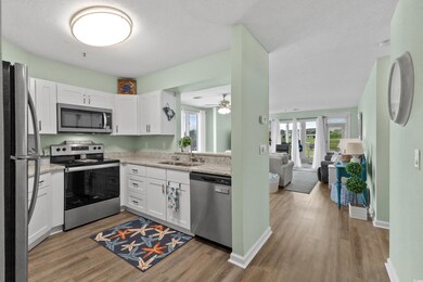 Kitchen featuring stainless steel appliances, a sink, wood finished floors, plenty of natural light, and a textured ceiling