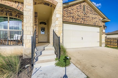 View of front of home with concrete driveway, brick siding, stone siding, and a garage