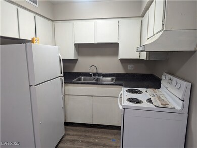 Kitchen with dark countertops, white cabinetry, a