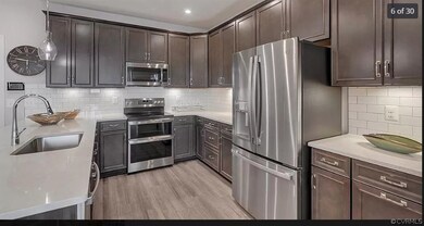 Kitchen with appliances with stainless steel finishes, sink, backsplash, and light hardwood / wood-style flooring