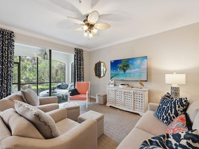 Living room featuring ornamental molding, a ceiling fan, and carpet floors
