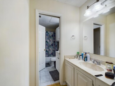 Full bath with tile patterned flooring, toilet, v