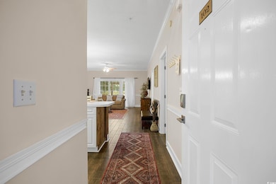 Hallway featuring crown molding and dark wood-type