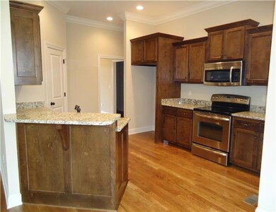 The kitchen is spacious with beautiful cabinetry, granite countertops, stainless appliances, pantry and eat-at bar.