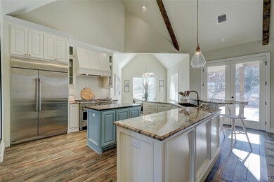 Kitchen with custom range hood, beam ceiling, an i