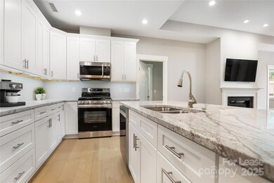 Open kitchen with granite countertops and soft close doors.
